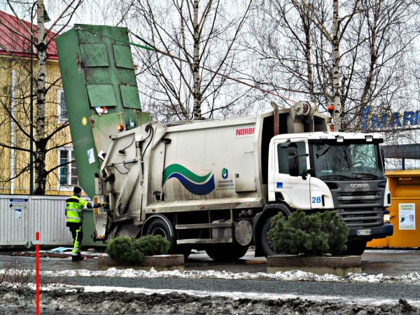 Scania P230
Varsin näppärästi käy keräyspaperiastian tyhjennys. Hytin takaa vinssiltä lähtee liinat, jotka on kiinnitetty astian takaosaan ja joilla se vedetään pystyyn pakkaajan kaukaloon ja tyhjennys alkaa.
Avainsanat: Scania Norba